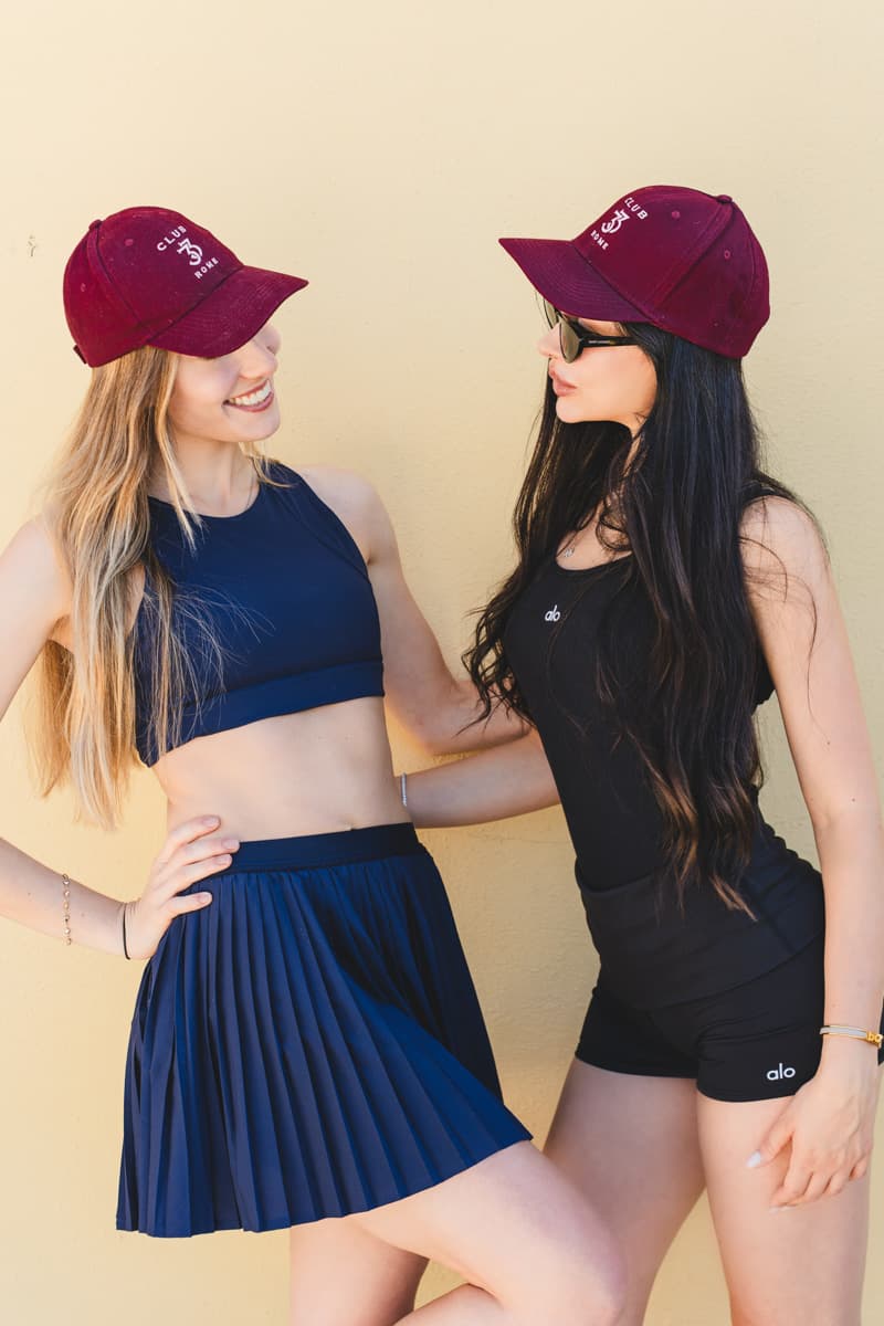 Due amiche sorridono con i cappellini bordeaux Club33